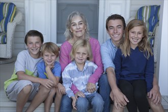 Caucasian grandmother and grandchildren smiling on porch