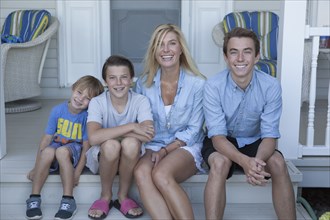 Caucasian mother and sons smiling on porch