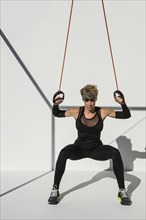 Caucasian athlete exercising with resistance cables