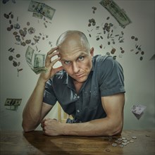 Caucasian man sitting in falling money