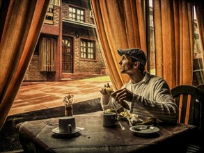 Caucasian man eating in cafe