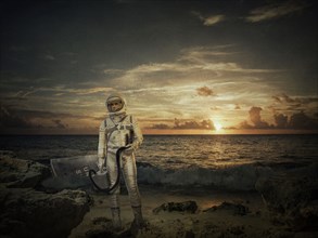 Caucasian astronaut standing on beach at sunset