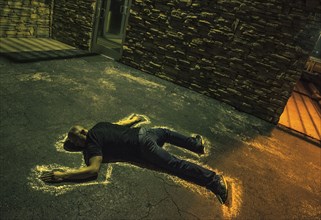 Chalk outline of body of Caucasian victim on pavement