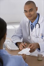 Male doctor handing prescription to patient