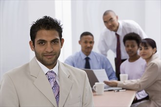 Indian businessman with co-workers in background