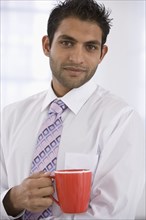 Indian businessman holding coffee mug
