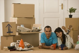 Young couple next to unpacked moving boxes
