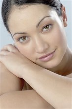 Mixed Race woman leaning face on arm