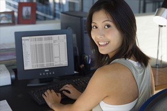 Asian woman typing on computer