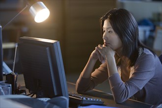 Asian businesswoman looking at computer
