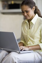 African American woman typing on laptop