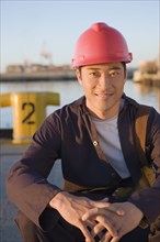 Asian male manual worker wearing hardhat