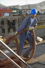 African American manual worker pulling on rope