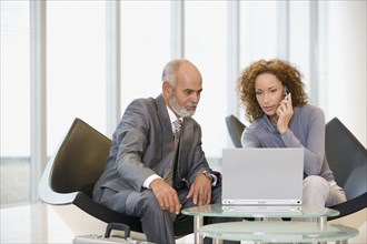 African businesspeople looking at laptop