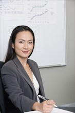 Asian businesswoman holding pen