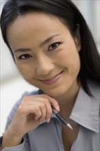 Asian businesswoman holding pen