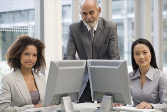 Multi-ethnic businesspeople behind computers