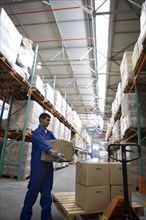 Worker stacking boxes in warehouse
