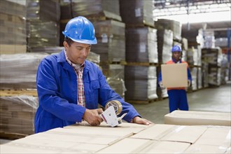 African worker taping boxes in warehouse