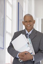 Confident African businessman holding paperwork