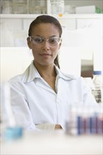 African scientist wearing safety goggles in laboratory