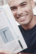 Smiling man reading magazine