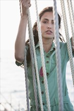 Caucasian woman holding ropes on sailboat