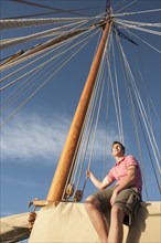 Caucasian man relaxing on sailboat