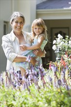 Grandmother and granddaughter admiring flowers