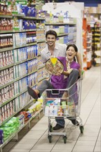 Playful Caucasian couple in grocery store
