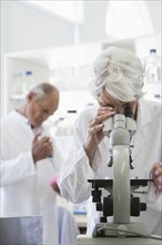 Senior Caucasian scientist using microscope in lab