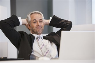 Businessman relaxing at desk in office