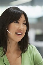 Asian businesswoman talking on headset