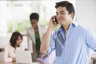 Businessman talking on cell phone in office