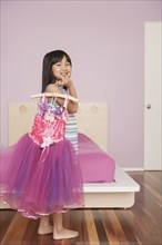 Chinese girl playing dress-up in bedroom