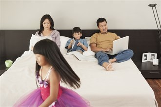 Family relaxing together in bedroom