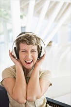 Woman listening to headphones on stairs