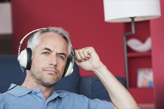 Man listening to headphones in living room