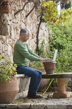 Man using laptop in backyard