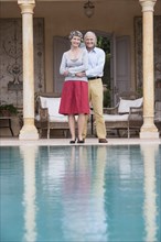 Couple standing by swimming pool