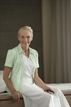 Senior Caucasian woman sitting on bed