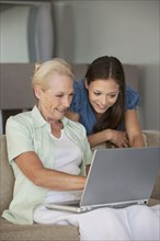 Caucasian mother and daughter using laptop