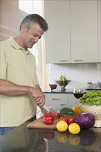 Hispanic man chopping vegetables in kitchen