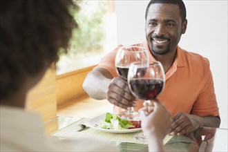 African American couple toasting each other at dinner