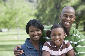 Family smiling together in park