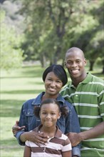 Family smiling together in park