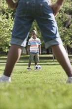 African American children playing soccer in park