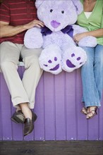 Caucasian couple with teddy bear at theme park