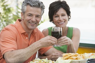 Caucasian couple toasting each other with wine