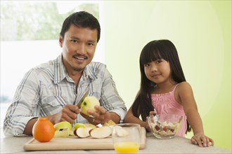 Asian father and daughter having breakfast together